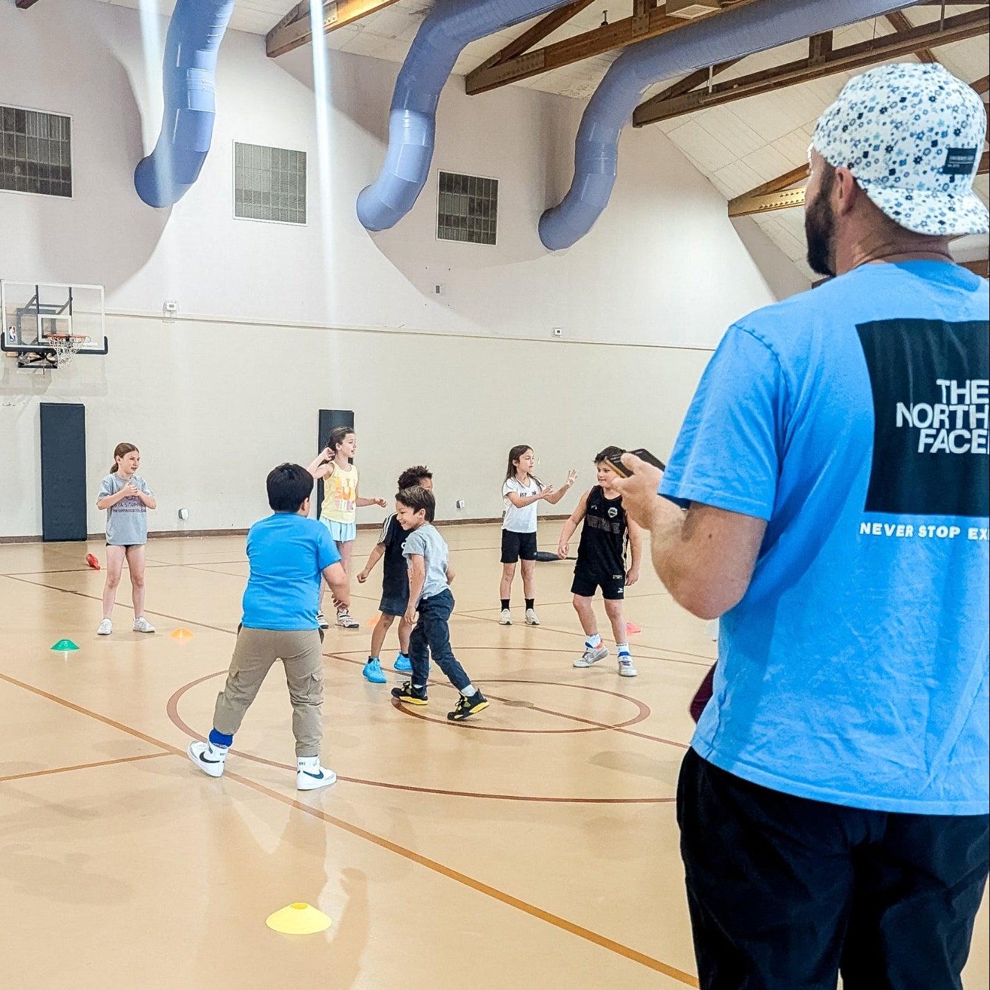 kids playing sports inside a basketball gym at a youth sports camp