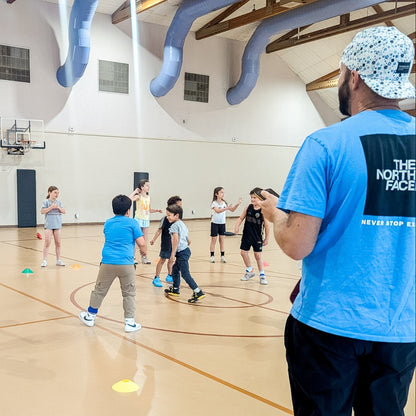 kids playing sports inside a basketball gym at a youth sports camp